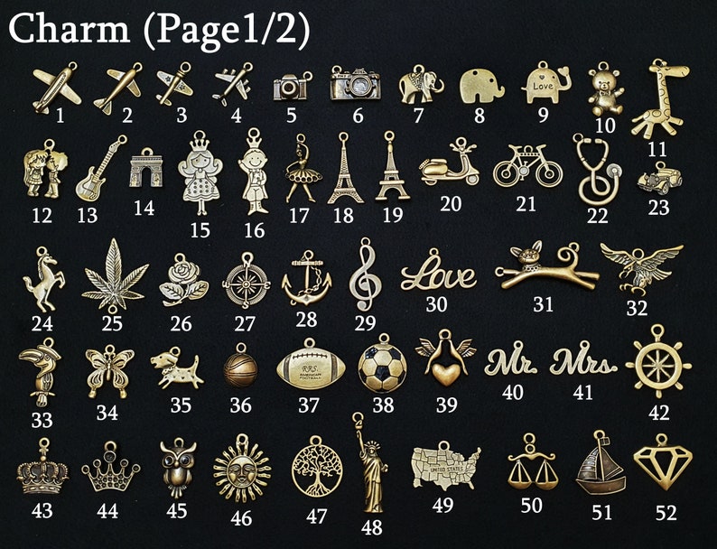 May include: A collection of gold-colored charms, each with a unique design. The charms include airplanes, cameras, animals, musical notes, and various other symbols. The text "Charm (Page 1/2)" is at the top.