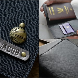 May include: A black leather wallet with a textured surface. The wallet has a personalized leather tag that reads "JACOB". A bronze basketball charm is also visible. The wallet is shown holding a passport and credit cards.