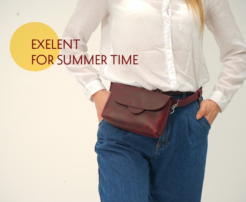 May include: A burgundy leather fanny pack with a flap closure and a matching belt. The bag is worn around the waist with a silver-colored clasp. The text "EXELENT FOR SUMMER TIME" is in the upper left corner.