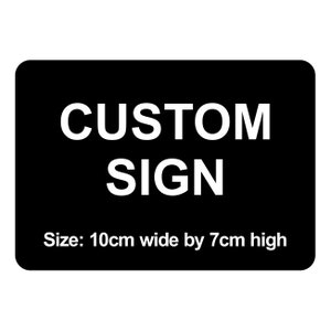 May include: Black sign with white text that reads "CUSTOM SIGN" and "Size: 10cm wide by 7cm high".