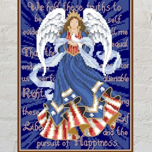 May include: Cross-stitch artwork of an angel in a blue dress with red and white accents, holding a dove. The artwork includes the text "We hold these truths...pursuit of Happiness" in a decorative frame.