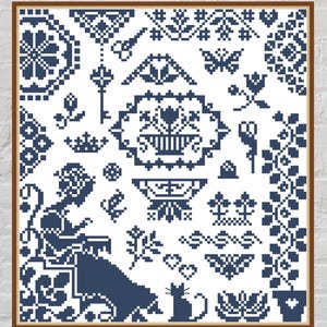 May include: A blue and white cross-stitch sampler featuring a variety of designs, including a seated woman, a cat, flowers, and a key. The sampler is framed in a brown wooden frame.