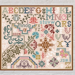 May include: A framed cross-stitch sampler with a beige background and a variety of colorful floral and geometric patterns. The sampler includes the alphabet, numbers, and the year 2024.