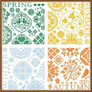 May include: A framed cross-stitch sampler with four squares depicting the seasons. The top left square is green and says "SPRING", the top right square is yellow and says "SUMMER", the bottom left square is blue and says "WINTER", and the bottom right square is orange and says "AUTUMN".