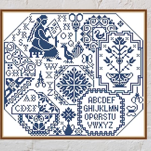 May include: Framed cross-stitch sampler in a wooden frame. The sampler features a variety of blue stitched motifs, including an alphabet, floral designs, a bird, and a woman. The sampler is displayed against a white brick wall.