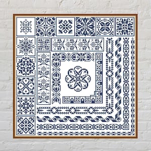 Może przedstawiać: Oprawiony sampler do haftu krzyżykowego z różnymi niebiesko-białymi geometrycznymi wzorami i obramowaniami. Sampler zawiera kwiatowe i symetryczne wzory, wyświetlane na białym tle. Rama jest w kolorze ciemnobrązowym.