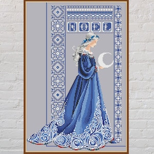 May include: Cross-stitch artwork in a wooden frame, depicting a woman in a long blue dress holding a crescent moon. The design has a medieval aesthetic, with detailed blue and white patterns. The word "NOEL" is stitched at the top.
