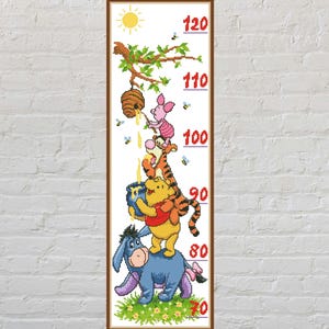 Könnte beinhalten: Ein gerahmtes Höhenmaß mit Winnie Puuh und seinen Freunden. Die Tafel zeigt Puuh, Tigger, Ferkel und I-Aah, mit Messungen von 70 bis 120 Zoll (ca. 178 bis 305 cm). Das Design umfasst eine Sonne, einen Bienenkorb und grünes Gras.