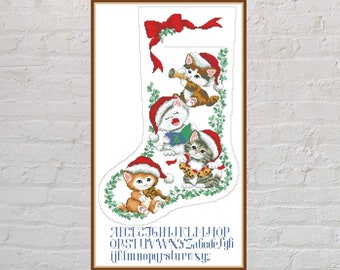 May include: A white Christmas stocking with a red ribbon and bow at the top. Four kittens wearing Santa hats are peeking out of the stocking. The kittens are playing musical instruments. The alphabet is printed at the bottom of the stocking.