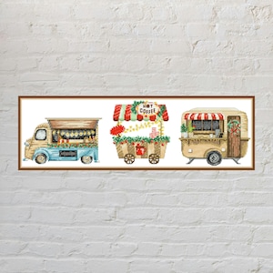 May include: A cross-stitch pattern featuring three food-themed vehicles: a light blue and tan food truck, a central cart with a red and white striped awning labelled HOT COFFEE, and a tan camper trailer decorated with a wreath and red striped awning.