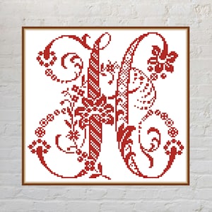 May include: A square cross-stitch pattern featuring a large, ornate letter H in deep red thread. The letter is decorated with intricate floral motifs, swirling vines, and geometric patterns, all rendered in a pixelated, counted cross-stitch style.