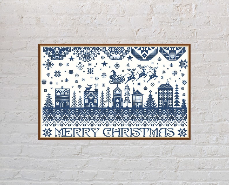 Pu&ograve; includere: Un motivo a punto croce blu e bianco con una scena di villaggio invernale, che include case, alberi e una slitta trainata da renne. Il testo "Merry Christmas" &egrave; in fondo al disegno.
