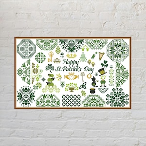 May include: A rectangular cross-stitch sampler featuring the text Happy St. Patrick's Day in the center. The design includes various green and gold motifs such as shamrocks, a leprechaun, a pot of gold, a harp, a cat, and intricate geometric patterns.