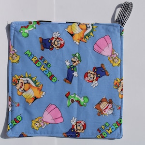 Könnte beinhalten: Blaues Küchentuch mit Super Mario World-Motiv. Das Handtuch zeigt Figuren wie Mario, Luigi, Prinzessin Peach, Yoshi und Bowser. Das Handtuch hat eine schwarz-weiß karierte Aufhängeschlaufe.