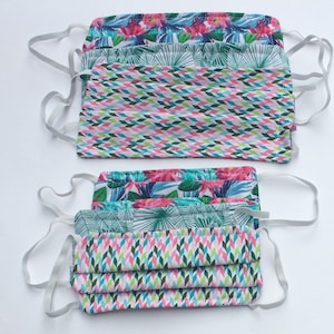 May include: A set of 10 reusable face masks with a variety of colorful floral and geometric patterns. The masks are made of fabric and have elastic ear loops.