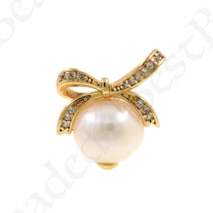 以下が含まれることがあります： パールとクリアなラインストーンのボウが付いたゴールドトーンのペンダント