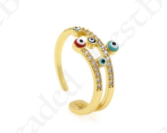 May include: Gold ring with two bands and multiple evil eye charms. The charms are blue, turquoise, and red with white pupils. The ring is adjustable.