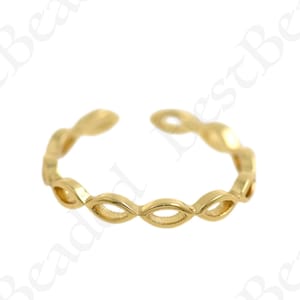 May include: A gold-toned adjustable ring with a delicate, openwork design featuring a repeating pattern of oval shapes.