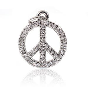 May include: A silver peace sign charm with clear rhinestones. The charm is a popular symbol of peace and love.