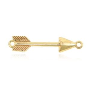 May include: A gold-colored arrow charm with a detailed fletching and arrowhead design. The charm has small loops on each end for attaching to jewelry. The arrow is a symbol of direction and focus.
