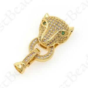 Könnte beinhalten: Goldfarbener Metallverschluss mit einem Pantherkopf-Design. Der Panther hat klare Strasssteine und grüne Augen. Der Verschluss ist für die Schmuckherstellung konzipiert.