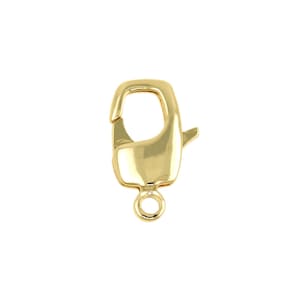 May include: A gold-colored lobster clasp, a jewelry component, is displayed against a white background. The clasp has a rounded rectangular body with a curved hook and a small loop at the bottom for attaching to jewelry.