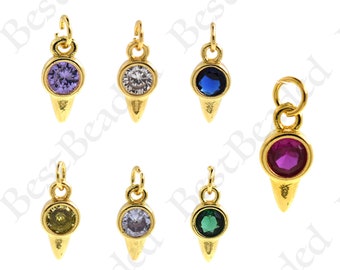 May include: Eight gold-tone charms with a pointed tip and a round bezel set with a single rhinestone. The rhinestones are in various colors, including clear, purple, blue, red, green, and yellow.