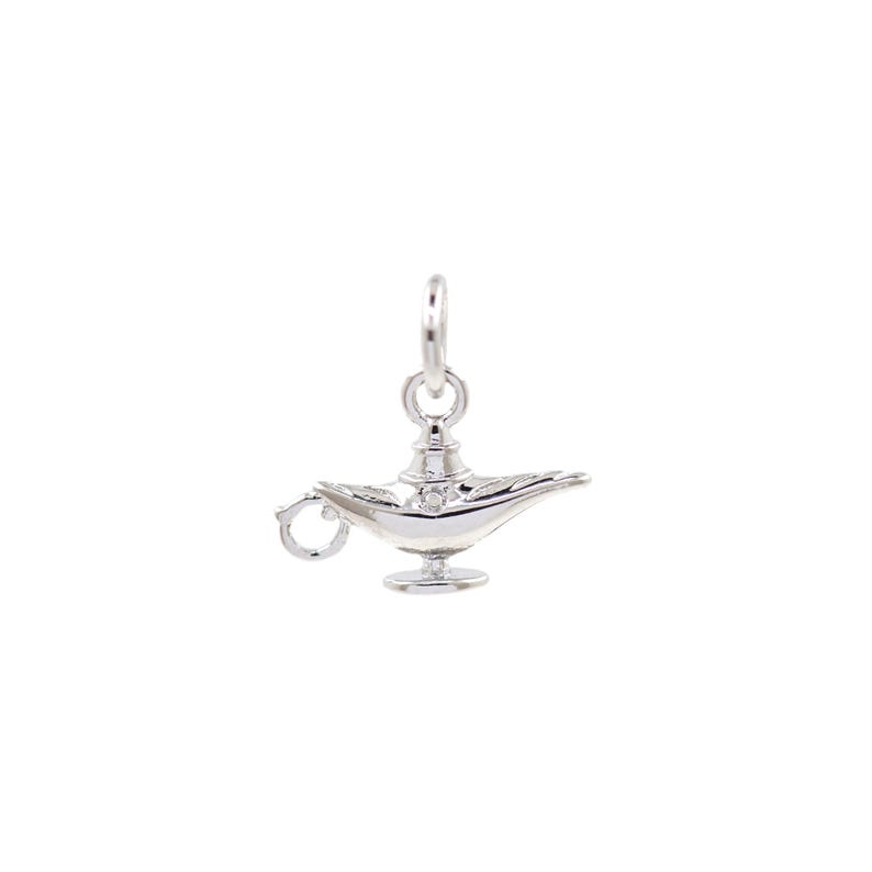 May include: A silver charm in the shape of a genie lamp. The lamp has a handle and a spout. The charm is detailed with intricate designs.