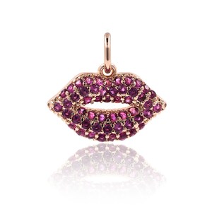 May include: A rose gold pendant charm in the shape of a pair of lips, encrusted with pink gemstones.