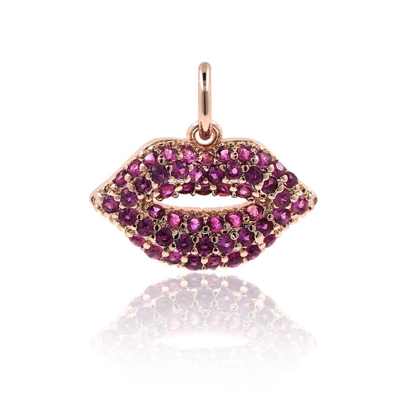 May include: A rose gold pendant charm in the shape of a pair of lips, encrusted with pink gemstones.