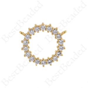 May include: Gold-toned pendant with a circular design featuring a row of clear cubic zirconia stones. The pendant has a loop at the top for attaching to a chain.