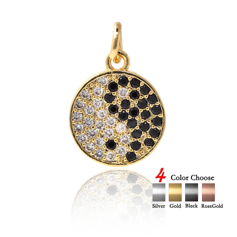 May include: Gold pendant necklace with a round yin yang charm featuring black and white cubic zirconia stones. The pendant is available in silver, gold, black, and rose gold.
