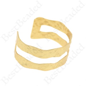May include: Gold-toned hammered metal cuff bracelet with two open spaces. The bracelet is open ended and adjustable.