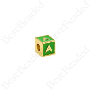 K&ouml;nnte beinhalten: Goldfarbener Buchstabenperle mit gr&uuml;ner Emaille-Beschichtung. Der Buchstabe "A" ist in Gold auf der Vorderseite der Perle gedruckt.