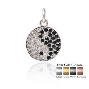 May include: A silver pendant necklace with a yin yang symbol made of black and white cubic zirconia stones. The pendant is available in four colors: silver, gold, black, and rose gold.