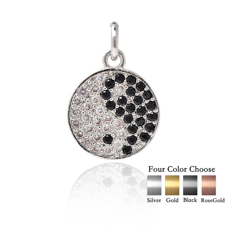 May include: A silver pendant necklace with a yin yang symbol made of black and white cubic zirconia stones. The pendant is available in four colors: silver, gold, black, and rose gold.
