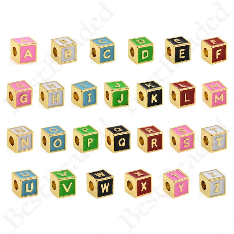 K&ouml;nnte beinhalten: Sechsundzwanzig goldfarbene Alphabet-Buchstabenperlen, jede mit einem anderen Buchstaben des Alphabets, in verschiedenen Farben. Die Perlen sind w&uuml;rfelf&ouml;rmig und haben ein Loch in der Mitte zum Aufziehen.