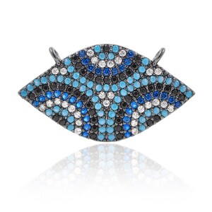 May include: A black metal charm in the shape of an eye with blue, white, and black crystal embellishments.