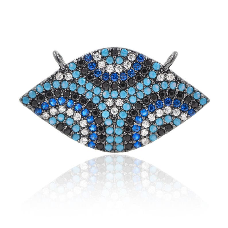 May include: A black metal charm in the shape of an eye with blue, white, and black crystal embellishments.