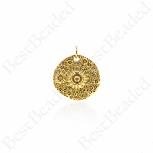 Puede incluir: Pendiente de encanto de color dorado con un diseño redondo y texturado con dos patrones de flores en relieve. El pendiente tiene un agujero en la parte superior para sujetarlo a una cadena o cordón.