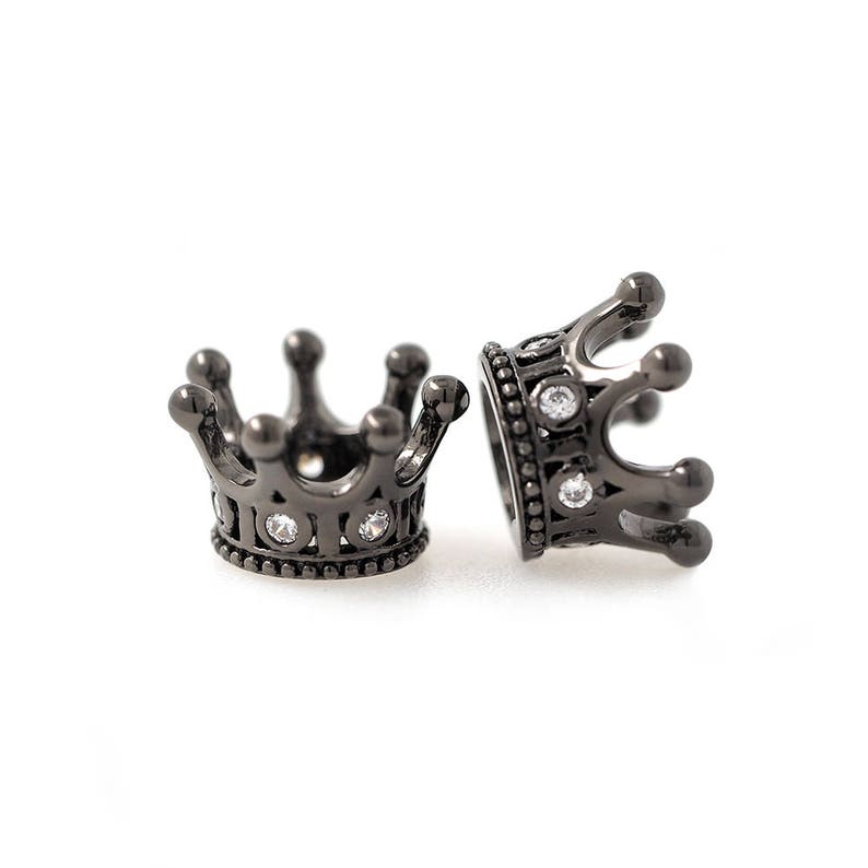 May include: Two black metal crown-shaped bead caps with clear rhinestone accents.
