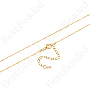 May include: A gold-toned chain necklace with a lobster clasp and an extender chain. The chain is made of small, round beads.