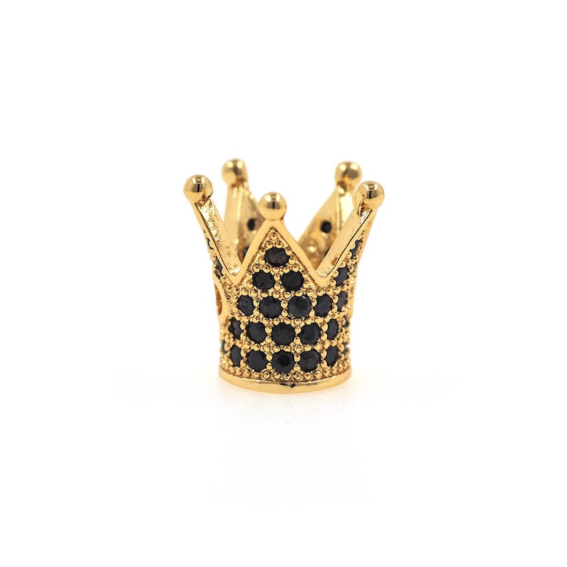 May include: A gold crown charm with black cubic zirconia stones. The crown is a popular charm for jewelry making and is a symbol of royalty.