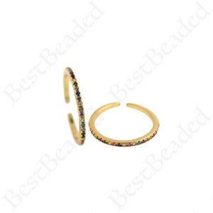 Peut inclure: Deux bagues en or avec une fine bande de pierres précieuses colorées. Les bagues sont ouvertes et réglables.