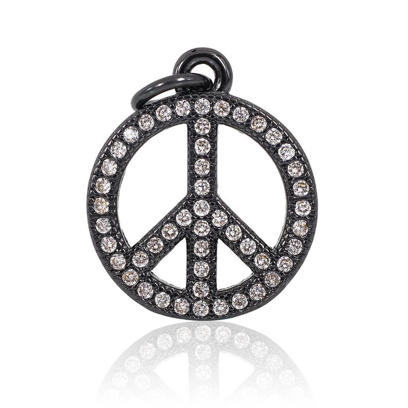 May include: Black peace sign charm with a pave setting of clear round stones.