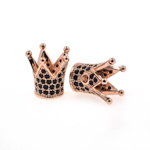 May include: Two gold-tone crown-shaped bead caps with black cubic zirconia stones. The caps are designed to be used as end caps for jewelry making.