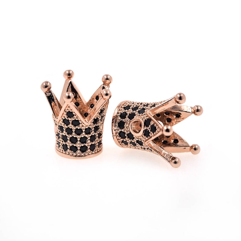 May include: Two gold-tone crown-shaped bead caps with black cubic zirconia stones. The caps are designed to be used as end caps for jewelry making.