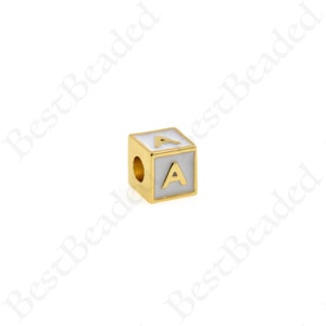 K&ouml;nnte beinhalten: Goldfarbener Alphabet-Perle mit einem wei&szlig;en Emaille-Buchstaben 'A' auf jeder Seite. Die Perle hat ein Loch zum Einf&auml;deln.