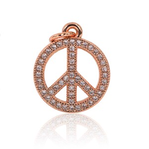 May include: A rose gold peace sign pendant with clear cubic zirconia stones.