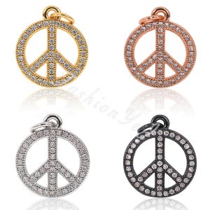 May include: Four peace sign charms with clear rhinestones. The charms are in gold, rose gold, silver, and black.